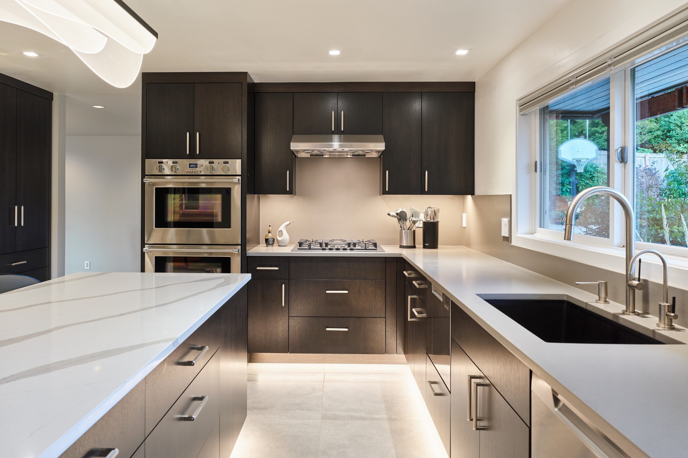 Luxury kitchen interior with dark cabinetry and marble island by Tom Bakker Design